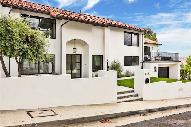 4335 Chaumont Rd, Woodland Hills, CA 91364 - view of front of house with a fenced front yard, a balcony, a tiled roof, and stucco siding