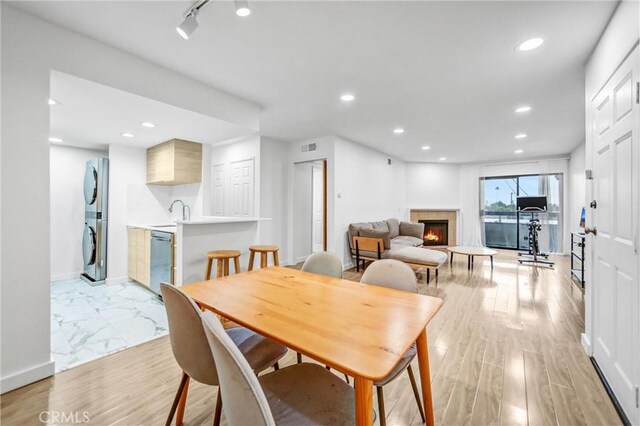 460 Oak St Unit 316, Glendale, CA 91204 - dining area featuring stacked washer and clothes dryer, a warm lit fireplace, recessed lighting, and baseboards