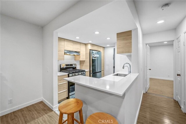 460 Oak St Unit 316, Glendale, CA 91204 - kitchen with gas stove, refrigerator, a sink, under cabinet range hood, and modern cabinets
