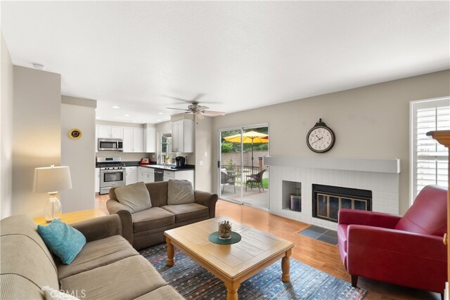 21242 Bristlecone, Mission Viejo, CA 92692 - living room featuring healthy amount of natural light, light wood-style floors, a brick fireplace, a ceiling fan, and recessed lighting