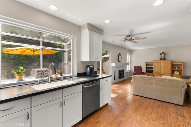 21242 Bristlecone, Mission Viejo, CA 92692 - kitchen featuring dishwasher, a sink, a fireplace, white cabinetry, and dark countertops