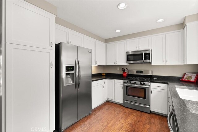21242 Bristlecone, Mission Viejo, CA 92692 - kitchen featuring appliances with stainless steel finishes, white cabinetry, dark countertops, recessed lighting, and wood finished floors
