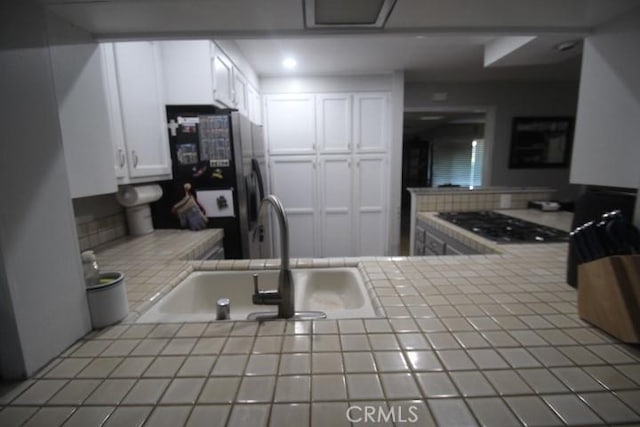 19555 Chadway St, Canyon Country, CA 91351 - kitchen with tile counters, a sink, freestanding refrigerator, and white cabinetry