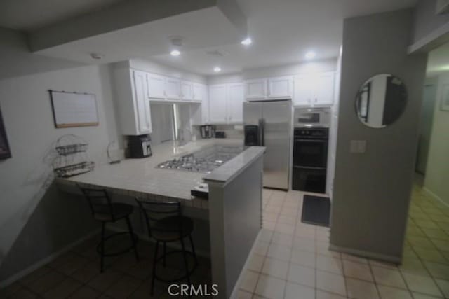 19555 Chadway St, Canyon Country, CA 91351 - kitchen featuring stainless steel fridge, a peninsula, white microwave, white cabinetry, and light countertops