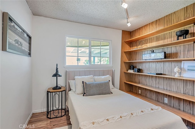 27049 Langside Ave, Canyon Country, CA 91351 - bedroom featuring wood finished floors, a textured ceiling, rail lighting, and baseboards