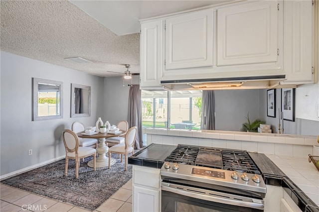 27049 Langside Ave, Canyon Country, CA 91351 - kitchen featuring stainless steel gas range, tile countertops, white cabinetry, healthy amount of natural light, and a textured ceiling