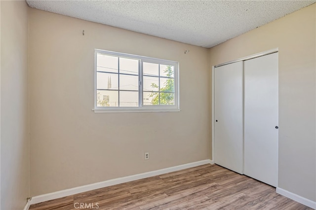 27049 Langside Ave, Canyon Country, CA 91351 - unfurnished bedroom with wood finished floors, a closet, a textured ceiling, and baseboards