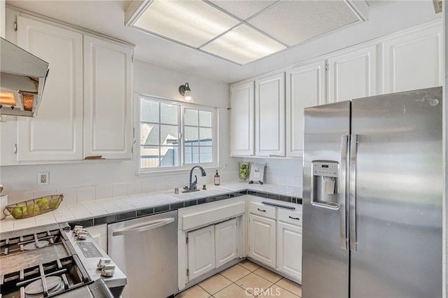 27049 Langside Ave, Canyon Country, CA 91351 - kitchen with stainless steel appliances, a sink, white cabinets, tile countertops, and light tile patterned floors