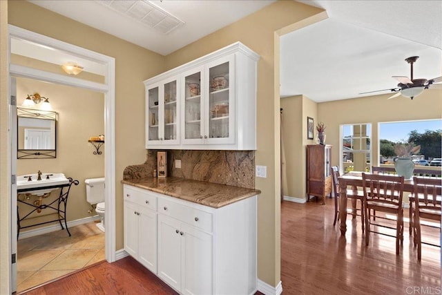 38161 Butterfly Ct, Yucaipa, CA 92399 - kitchen featuring a ceiling fan, white cabinets, tasteful backsplash, wood finished floors, and glass insert cabinets