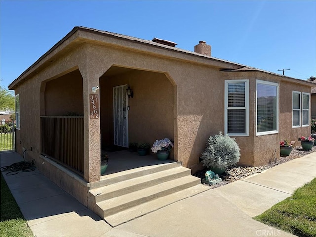 34662 Turner Ln, Yucaipa, CA 92399 - view of front of home featuring stucco siding, a chimney, and covered porch