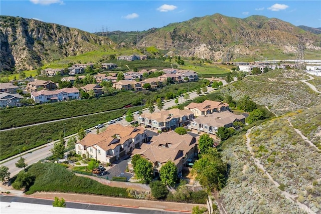 aerial view of property and surrounding area featuring a mountain backdrop and nearby suburban area