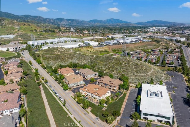 aerial view of property and surrounding area featuring a mountainous background and nearby suburban area
