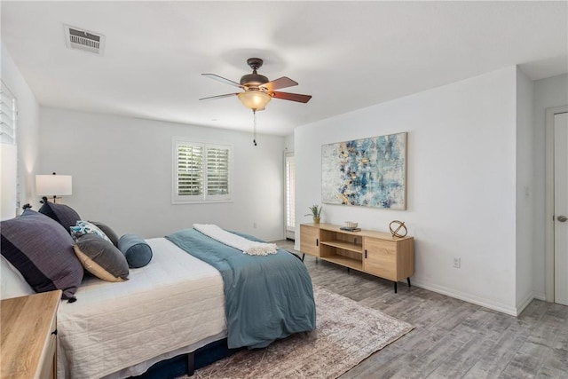 bedroom with light wood-type flooring, baseboards, and ceiling fan