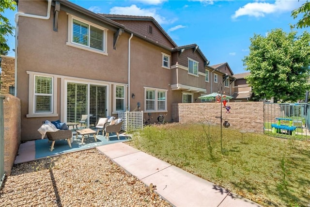back of property with stucco siding, a patio area, and an outdoor living space