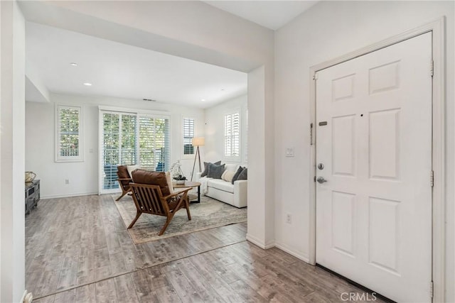 foyer entrance featuring wood finished floors, baseboards, and recessed lighting