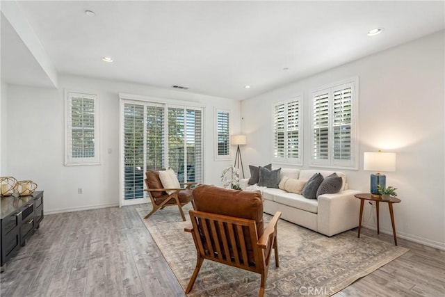 living room with light wood-type flooring, baseboards, and recessed lighting