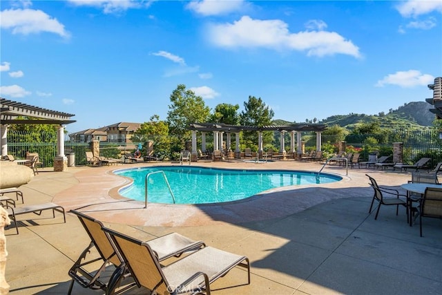 community pool featuring a pergola, fence, and a patio