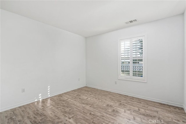 spare room featuring wood finished floors and baseboards