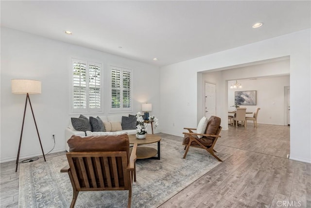 living room with a chandelier, light wood-style flooring, recessed lighting, and baseboards