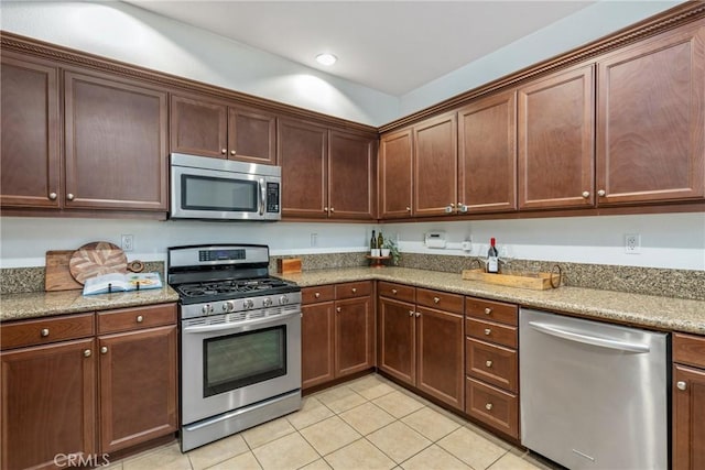 kitchen featuring stainless steel appliances, light tile patterned flooring, light stone countertops, and recessed lighting