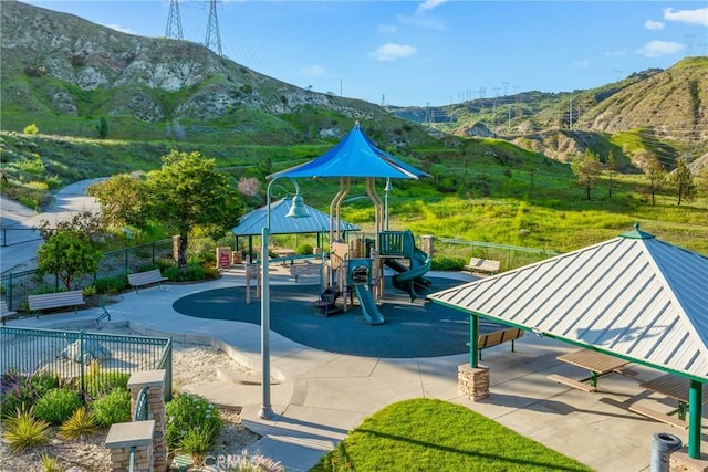 view of property's community with a mountain view and fence