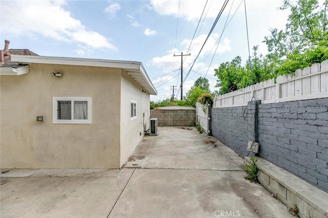 1411 Coolidge Ave, Pasadena, CA 91104 - view of side of home with a fenced backyard, stucco siding, a patio, and cooling unit