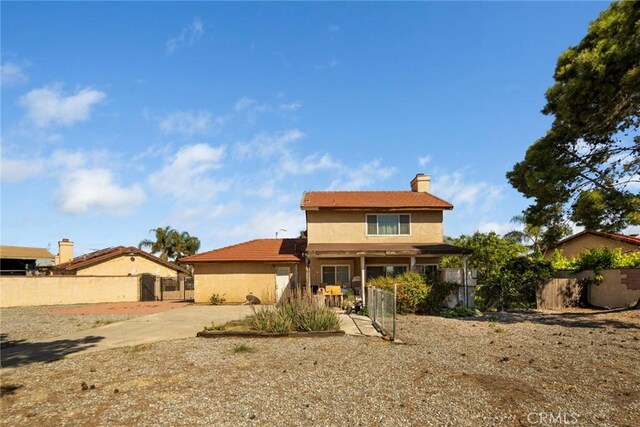 14881 Hawthorne Ave, Fontana, CA 92335 - rear view of house with fence, a chimney, a patio area, and stucco siding