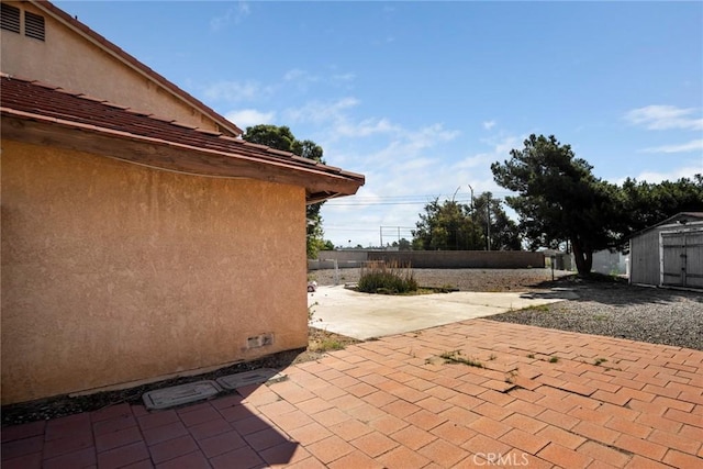 14881 Hawthorne Ave, Fontana, CA 92335 - view of patio featuring a shed, fence, and an outbuilding