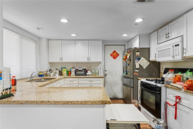 14881 Hawthorne Ave, Fontana, CA 92335 - kitchen featuring white microwave, gas stove, a sink, white cabinets, and recessed lighting