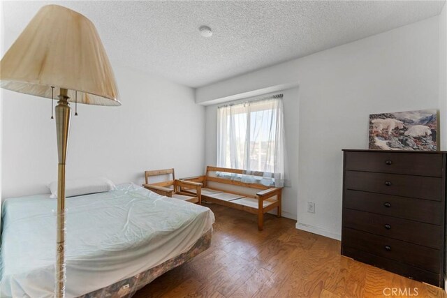 14881 Hawthorne Ave, Fontana, CA 92335 - bedroom featuring wood finished floors and a textured ceiling