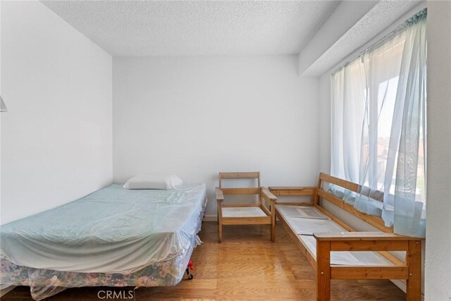 14881 Hawthorne Ave, Fontana, CA 92335 - bedroom with a textured ceiling and wood finished floors