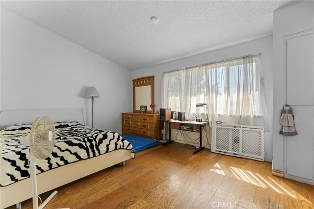 14881 Hawthorne Ave, Fontana, CA 92335 - bedroom featuring a textured ceiling, light wood-type flooring, and lofted ceiling