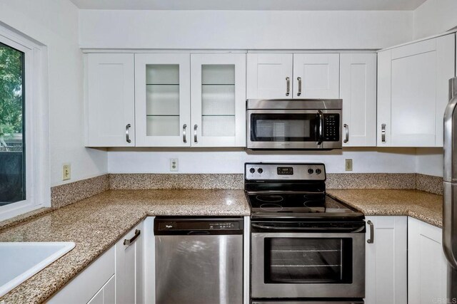 1307 Caminito Gabaldon Unit B, San Diego, CA 92108 - kitchen with appliances with stainless steel finishes, white cabinets, glass insert cabinets, and a sink