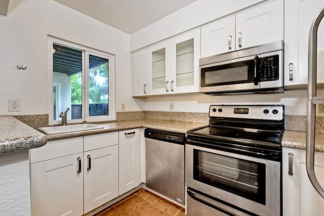 1307 Caminito Gabaldon Unit B, San Diego, CA 92108 - kitchen featuring appliances with stainless steel finishes, a sink, white cabinetry, glass insert cabinets, and light countertops
