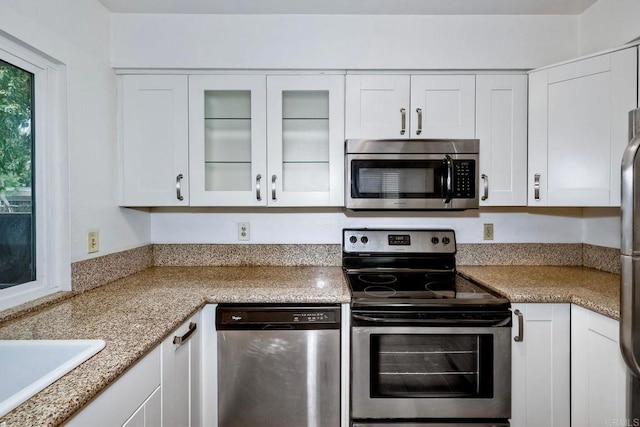 1307 Caminito Gabaldon Unit B, San Diego, CA 92108 - kitchen with stainless steel appliances, white cabinetry, glass insert cabinets, and a sink