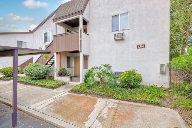 1307 Caminito Gabaldon Unit B, San Diego, CA 92108 - view of front of property with stairs, stucco siding, roof with shingles, and a wall mounted AC