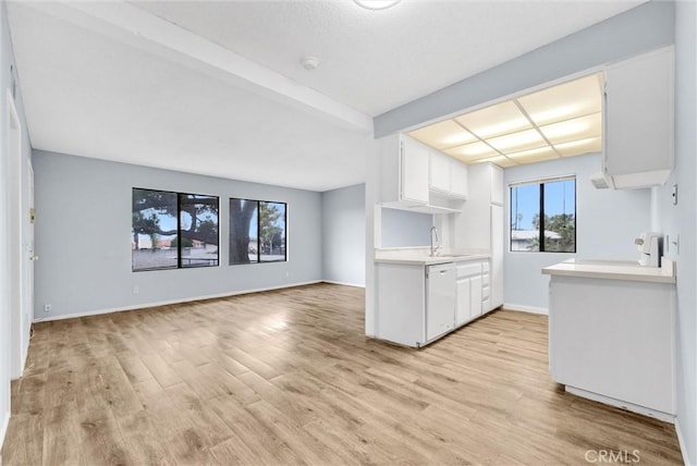 1735 E Washington St Unit B28, Colton, CA 92324 - kitchen with white dishwasher, a sink, light countertops, light wood-type flooring, and white cabinets