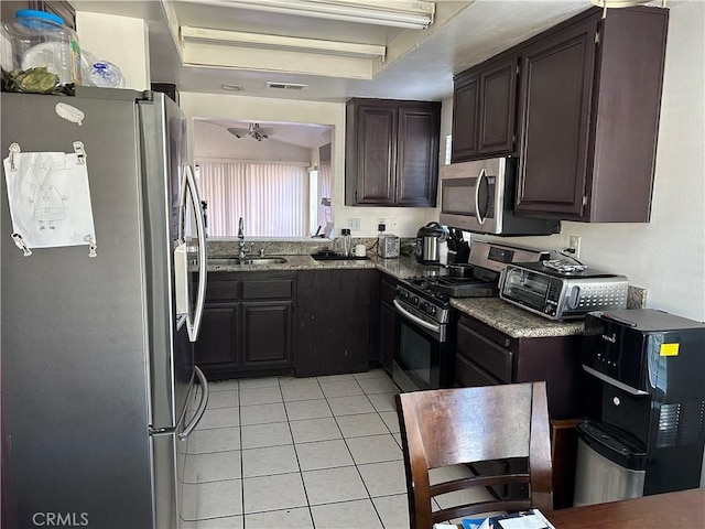 532 Hayes Cir, Corona, CA 92879 - kitchen featuring stainless steel appliances, a sink, light tile patterned floors, dark stone countertops, and dark brown cabinets