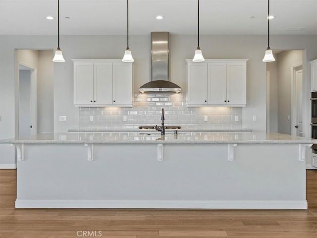 920 Trail View Pl, Nipomo, CA 93444 - kitchen with wall chimney range hood, white cabinets, backsplash, a breakfast bar area, and recessed lighting