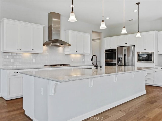 920 Trail View Pl, Nipomo, CA 93444 - kitchen featuring wall chimney range hood, appliances with stainless steel finishes, a sink, wood finished floors, and white cabinets