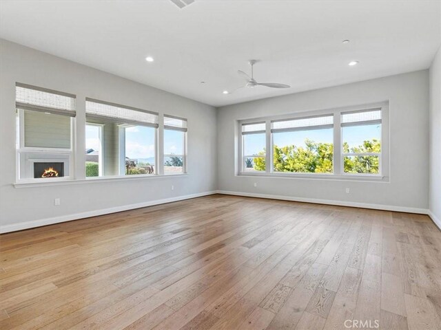 920 Trail View Pl, Nipomo, CA 93444 - unfurnished room with wood-type flooring, baseboards, ceiling fan, recessed lighting, and a warm lit fireplace