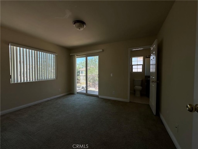 carpeted spare room featuring healthy amount of natural light and baseboards