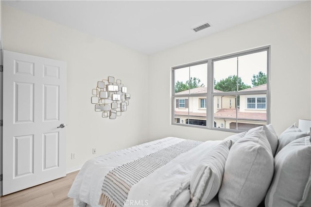 bedroom featuring light wood-style floors and baseboards