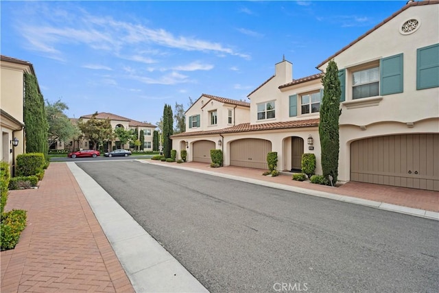 view of asphalt road with sidewalks, a residential view, and curbs