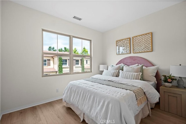 bedroom featuring wood finished floors and baseboards