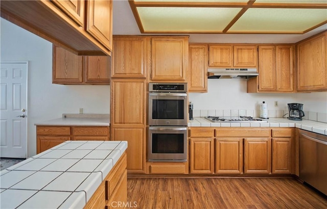 35823 48th St E, Palmdale, CA 93552 - kitchen featuring stainless steel appliances, under cabinet range hood, and tile counters