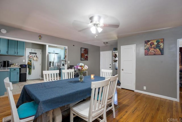 dining area with a ceiling fan, baseboards, and light wood-type flooring