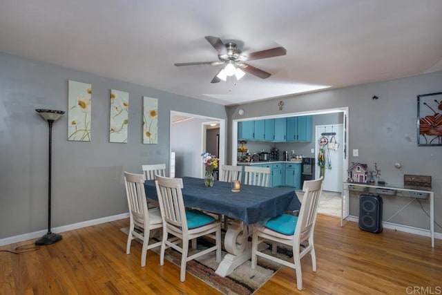 dining area with light wood-style floors, ceiling fan, and baseboards