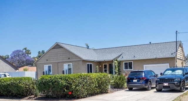 single story home featuring stucco siding, a garage, concrete driveway, and roof with shingles