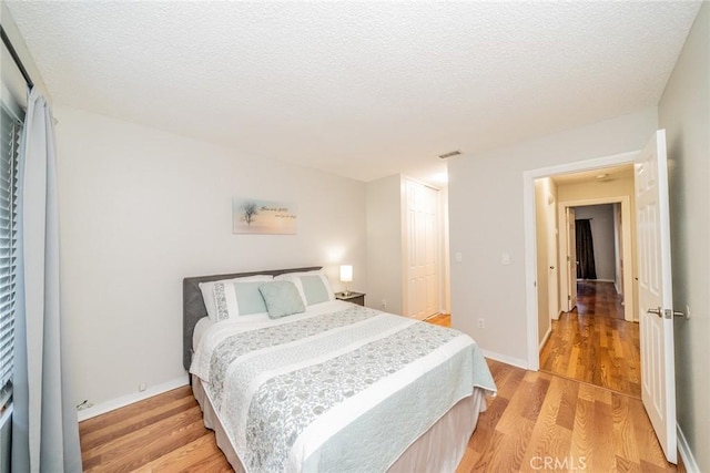 3628 Grizzley Creek Ct, Ontario, CA 91761 - bedroom with light wood-style flooring, a textured ceiling, a closet, and baseboards